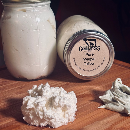 Two jars of 'Generations Beef' Pure Wagyu Tallow on a wooden surface with some tallow outside the jars.

